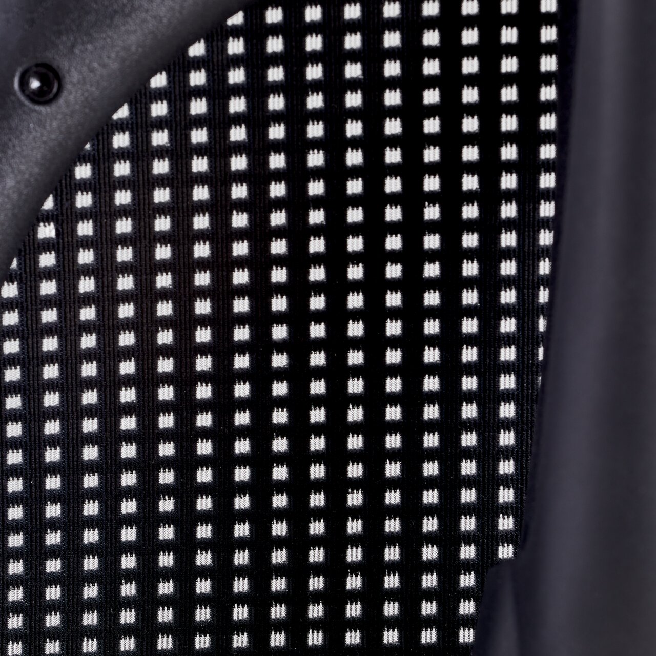 Nahaufnahme der Rückenlehne eines Drehstuhls mit schwarz-weißem Gittermuster