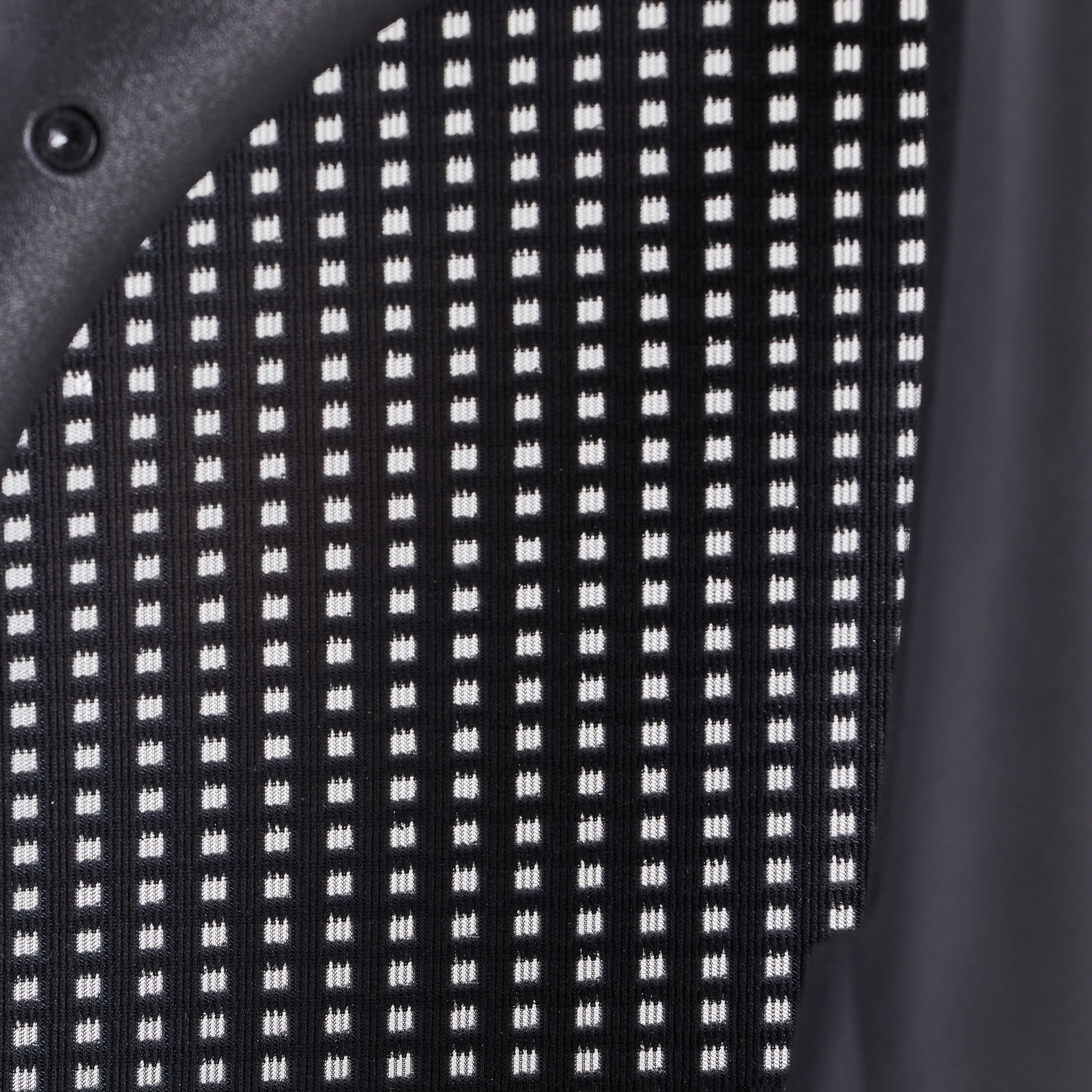 Nahaufnahme der Rückenlehne eines Drehstuhls mit schwarz-weißem Gittermuster