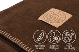 Nahaufnahme einer braunen Wohndecke mit Söller Home Logo, kuschelig und warm, hergestellt in Portugal, 100% nachhaltig.