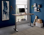 Moderner höhenverstellbarer E-Schreibtisch in einem stilvollen Büro mit Blick aus dem Fenster, seitliche Perspektive.