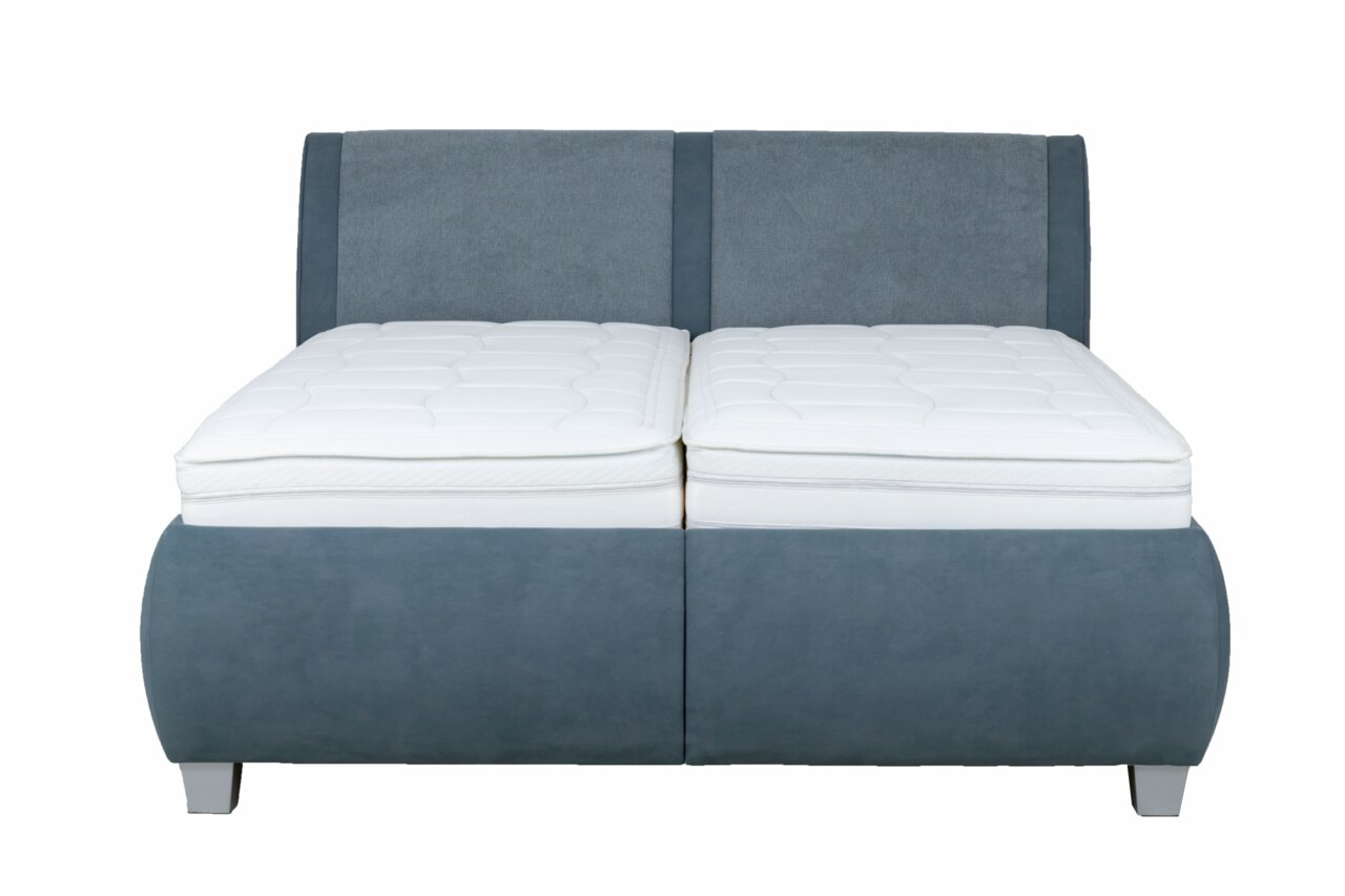 Frontale Ansicht eines modernen Polsterbetts mit grauem Stoffbezug und weißer Matratze.