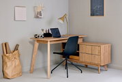Moderner Eck-Schreibtisch aus Holz mit Schubladen, schwarzem Stuhl und Schreibtischlampe, seitliche Perspektive