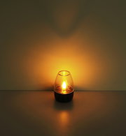 Solarleuchte in einem dunklen Raum, leuchtend mit warmem Licht, seitliche Perspektive