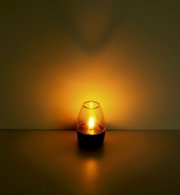 Solarleuchte in einem dunklen Raum, leuchtend mit warmem Licht, seitliche Perspektive