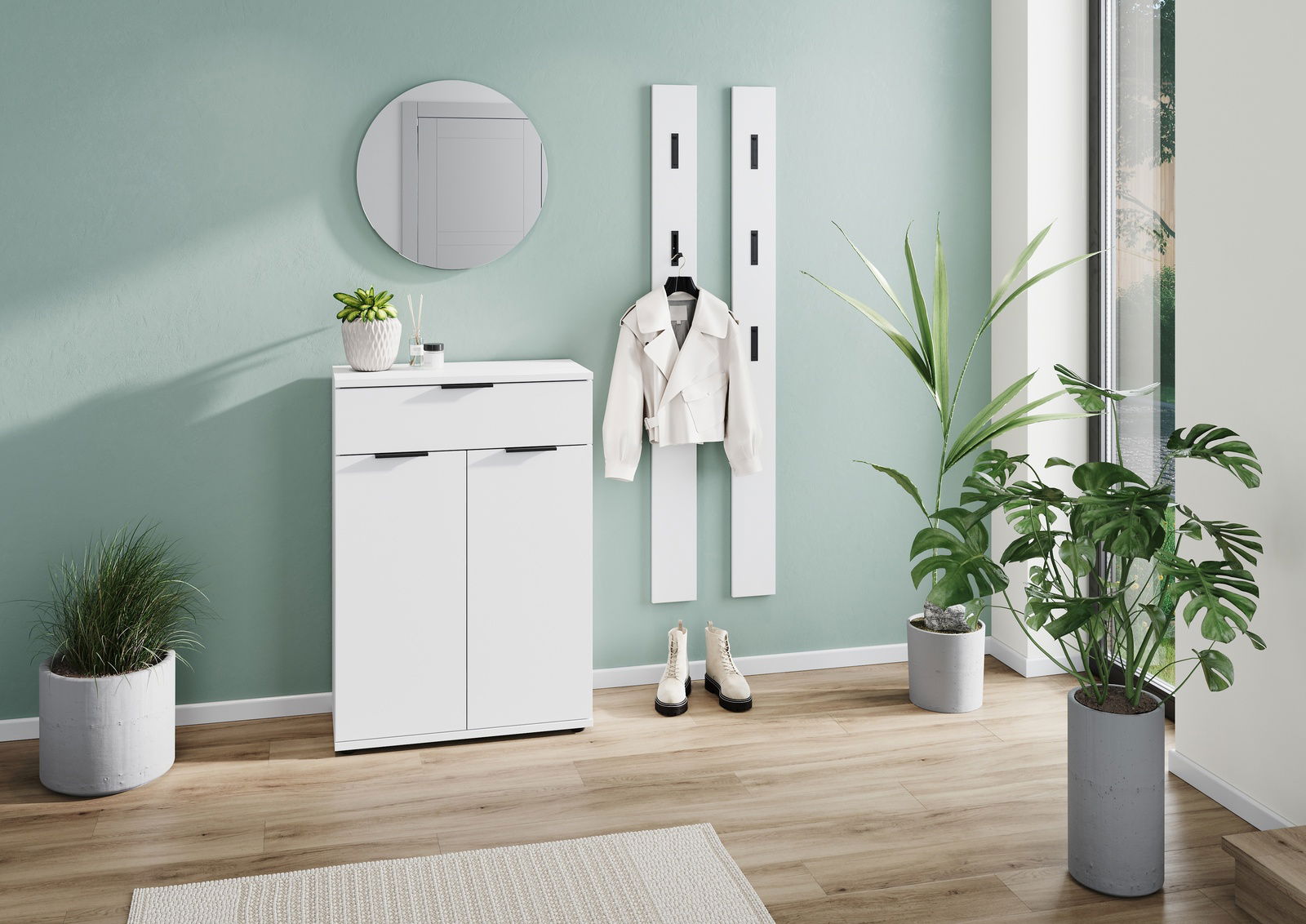 Moderner weißer Schuhschrank in einem hellen Raum mit Pflanzen, einem runden Spiegel und einer Jacke an der Wand. Perspektive von vorne.