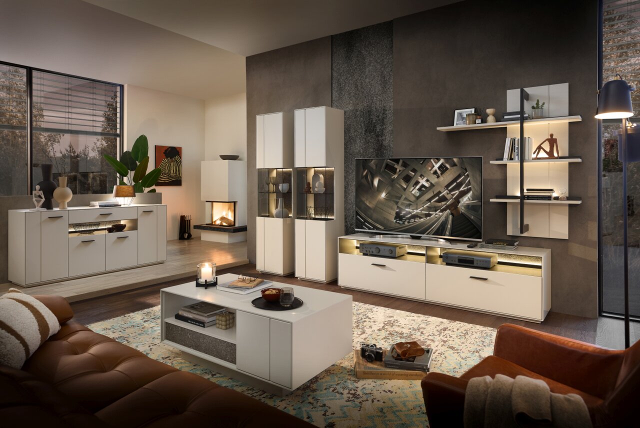 Moderne woonkamer met dressoir COMO van Zurbrüggen, gezien vanaf de voorkant. Elegant ontwerp met ingebouwde verlichting en decoratieve elementen.
