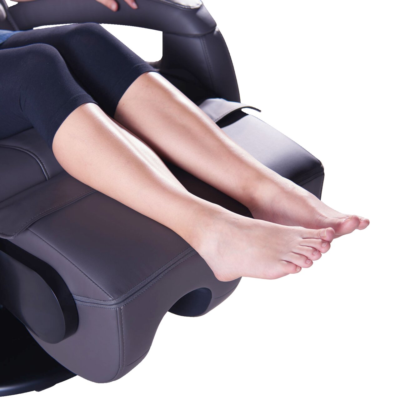 Close-up van een massagestoel met de gestrekte benen van een persoon die op de voetsteun rust, gezien vanuit een zijdelingse hoek.