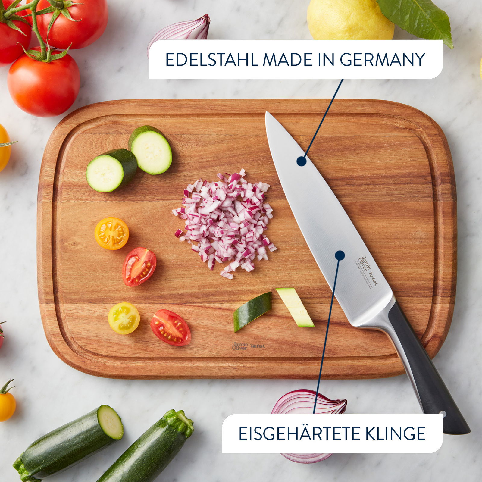 Vogelperspektive auf ein Schneidebrett mit einem Messer aus Edelstahl, umgeben von geschnittenem Gemüse und Zwiebeln.