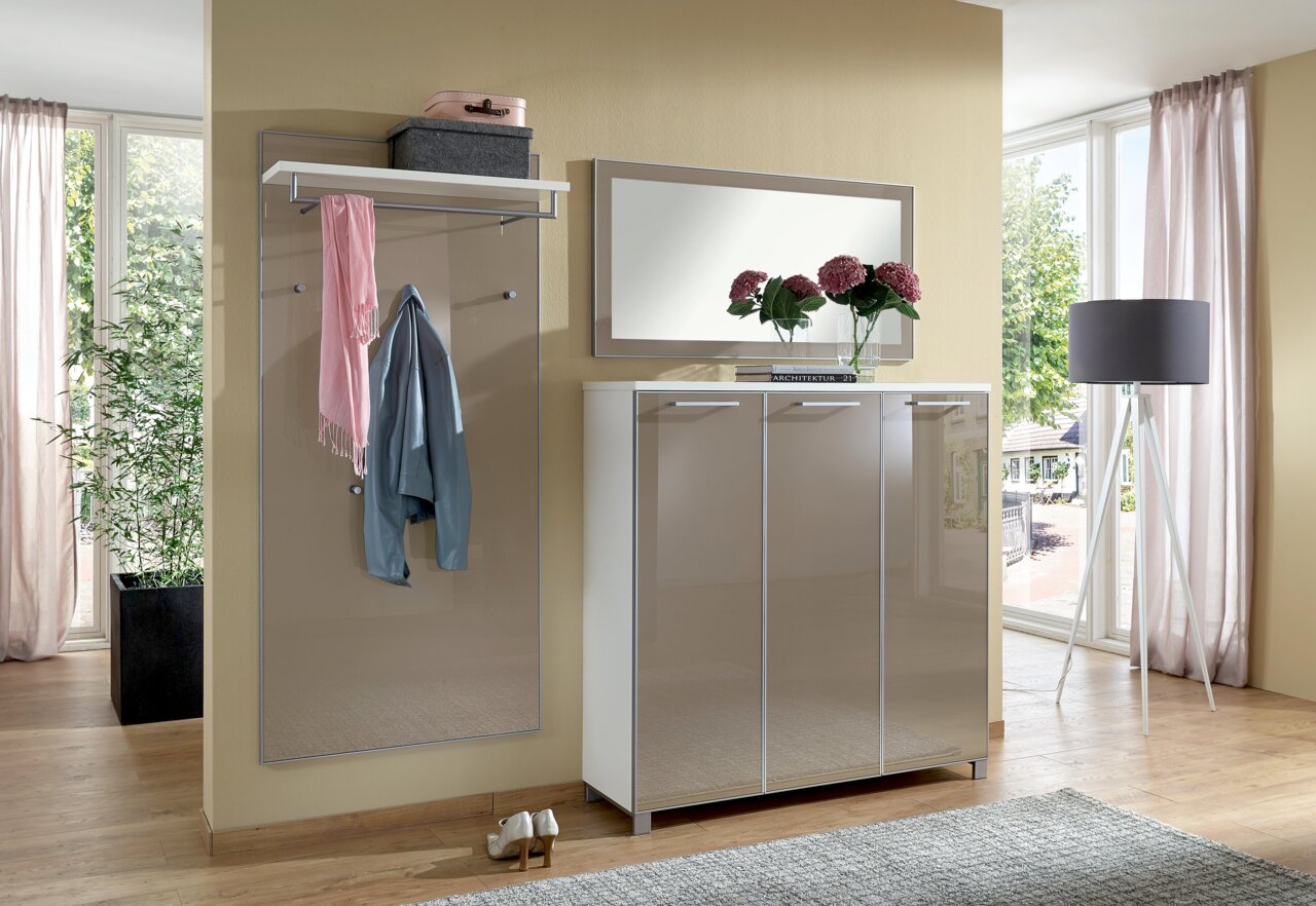 Moderner Eingangsbereich mit Garderobenpaneel, Spiegel und Schuhschrank in heller, eleganter Optik. Perspektive von vorne.