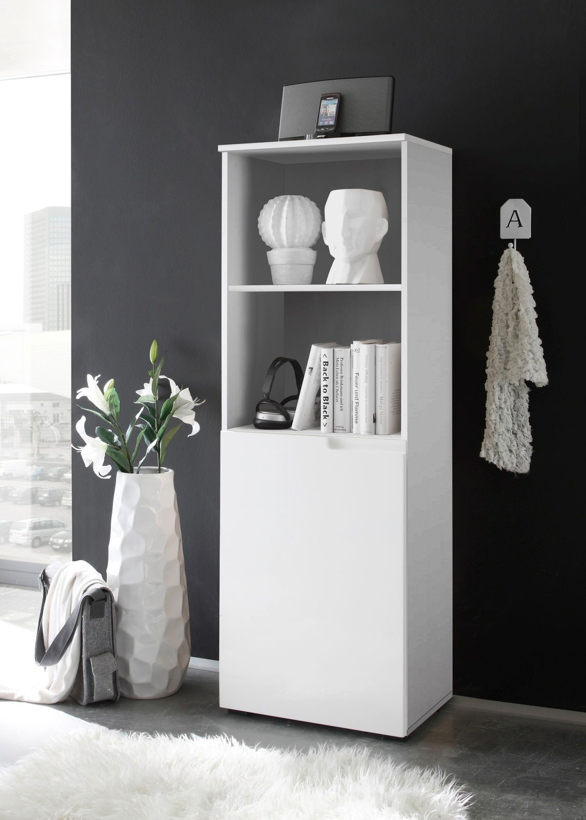 Weißes halbhohes Regal mit zwei offenen Fächern und einer Tür, seitliche Perspektive