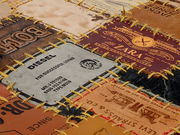 Nahaufnahme eines Lederteppichs aus verschiedenen Markenetiketten, perspektivisch von oben fotografiert.