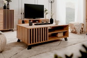 Moderne houten salontafel met zwarte accenten, van voren gefotografeerd in een stijlvol ingerichte woonkamer.