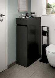 Schwarzer, mattierter Bad-Unterschrank mit Schublade und Ablagefläche, seitlich neben WC in modernem Badezimmer, perspektivisch schräg von vorn links aufgenommen.