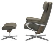 Seitenansicht eines braunen Stressless Einzelsessels mit passendem Hocker, beide mit Metall- und Holzelementen.