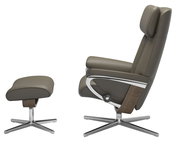 Seitenansicht eines braunen Stressless Einzelsessels mit passendem Hocker, beide mit Metall- und Holzelementen.