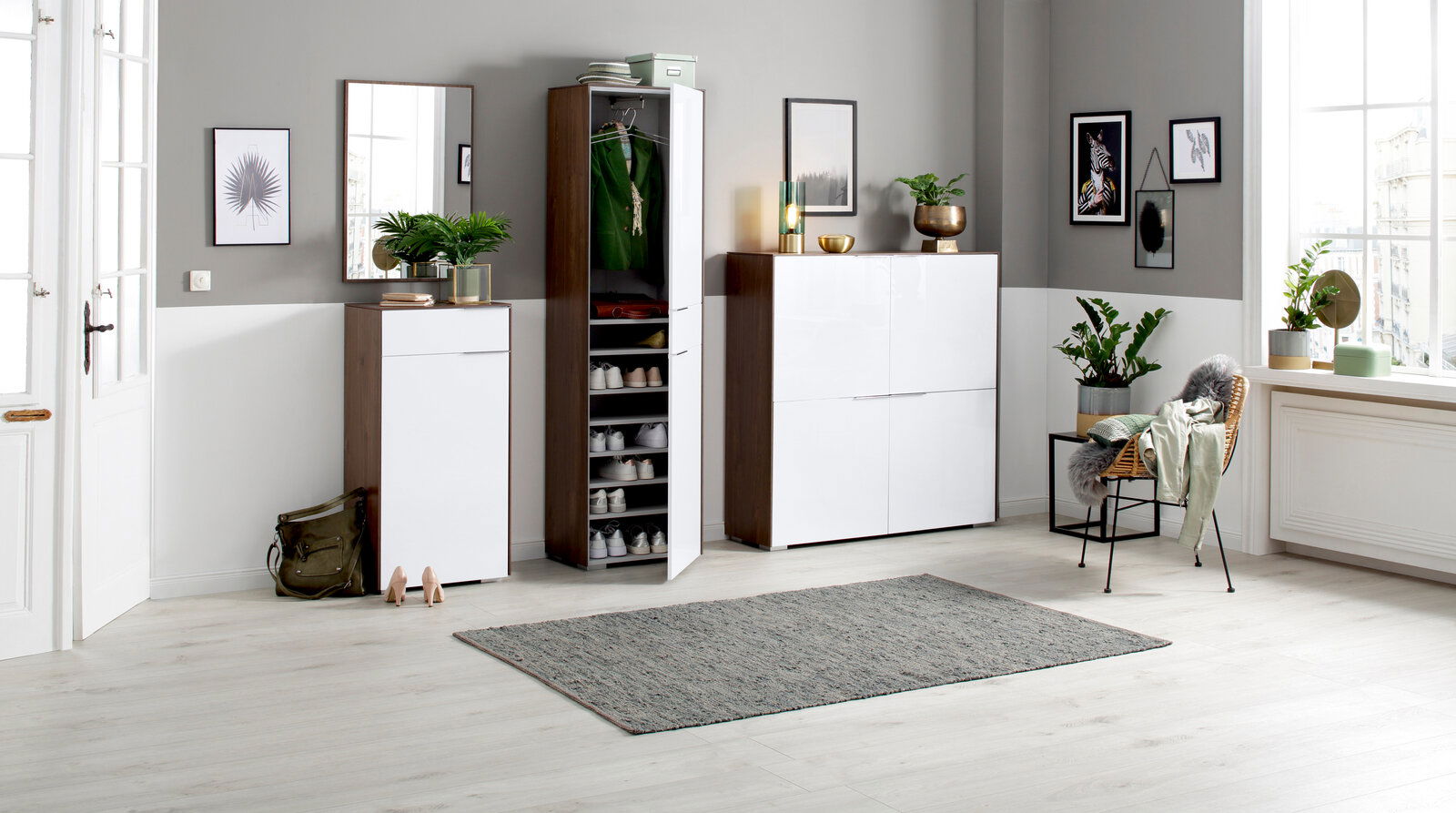 Moderne Garderobeneinrichtung mit Schuhschränken, Spiegel und Pflanzen in einem hellen Raum, seitliche Perspektive.