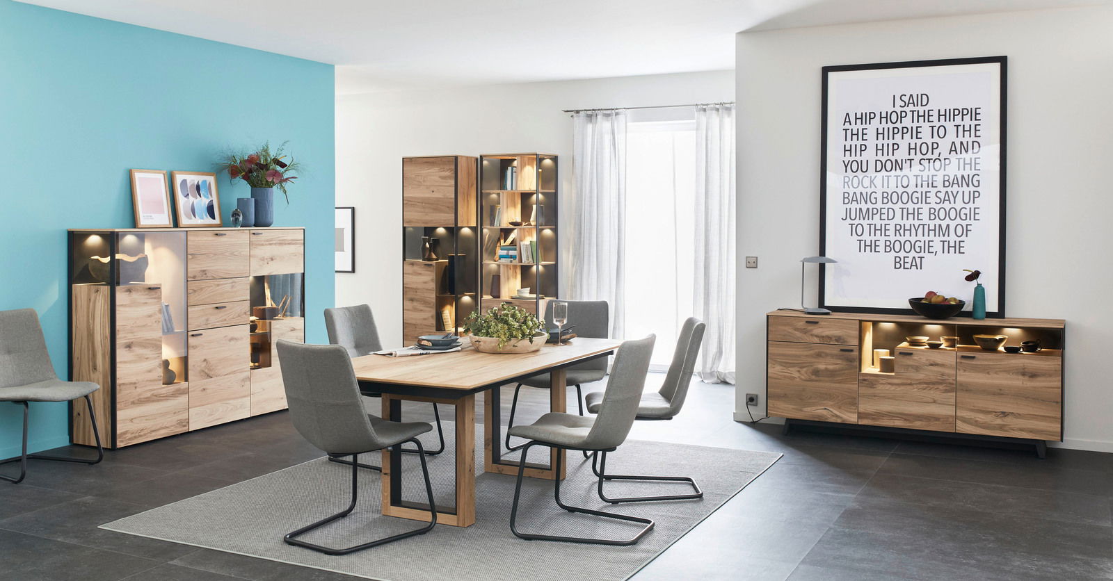 Schöner Wohnen Highboard ANDRA Modernes Highboard aus Holz mit Glasvitrinen, dekoriert mit Pflanzen und Kunstwerken, in einem stilvollen Esszimmer. Perspektive: Frontalansicht.