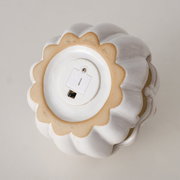 Unteransicht eines weißen, dekorativen Kürbisses mit Batteriefach.