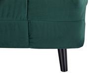 Nahaufnahme eines grünen Funktionssessels mit schwarzem Bein, seitliche Perspektive