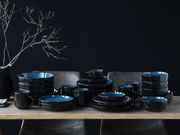 Kombiservice 30-tlg. Blue in eleganter schwarzer und blauer Keramik, auf einem Tisch arrangiert, seitliche Perspektive.