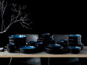 Kombiservice 30-tlg. Blue in eleganter schwarzer und blauer Keramik, auf einem Tisch arrangiert, seitliche Perspektive.