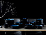 Kombiservice 30-tlg. Blue in eleganter schwarzer und blauer Keramik, auf einem Tisch arrangiert, seitliche Perspektive.