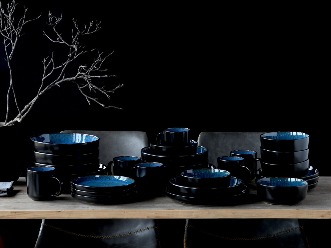 Kombiservice 30-delig Blue in elegante zwarte en blauwe keramiek, op een tafel uitgestald, zijaanzicht.