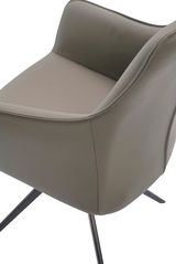 Nahaufnahme eines modernen Armlehnstuhls mit grauem Polster und schwarzen Metallbeinen, seitliche Perspektive.