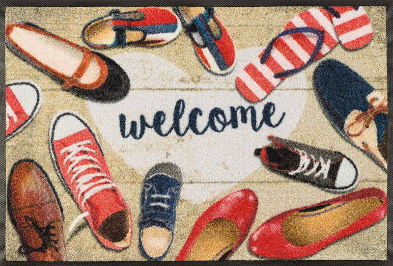Fußmatte mit verschiedenen Schuhen und dem Schriftzug 'welcome' aus der Vogelperspektive.