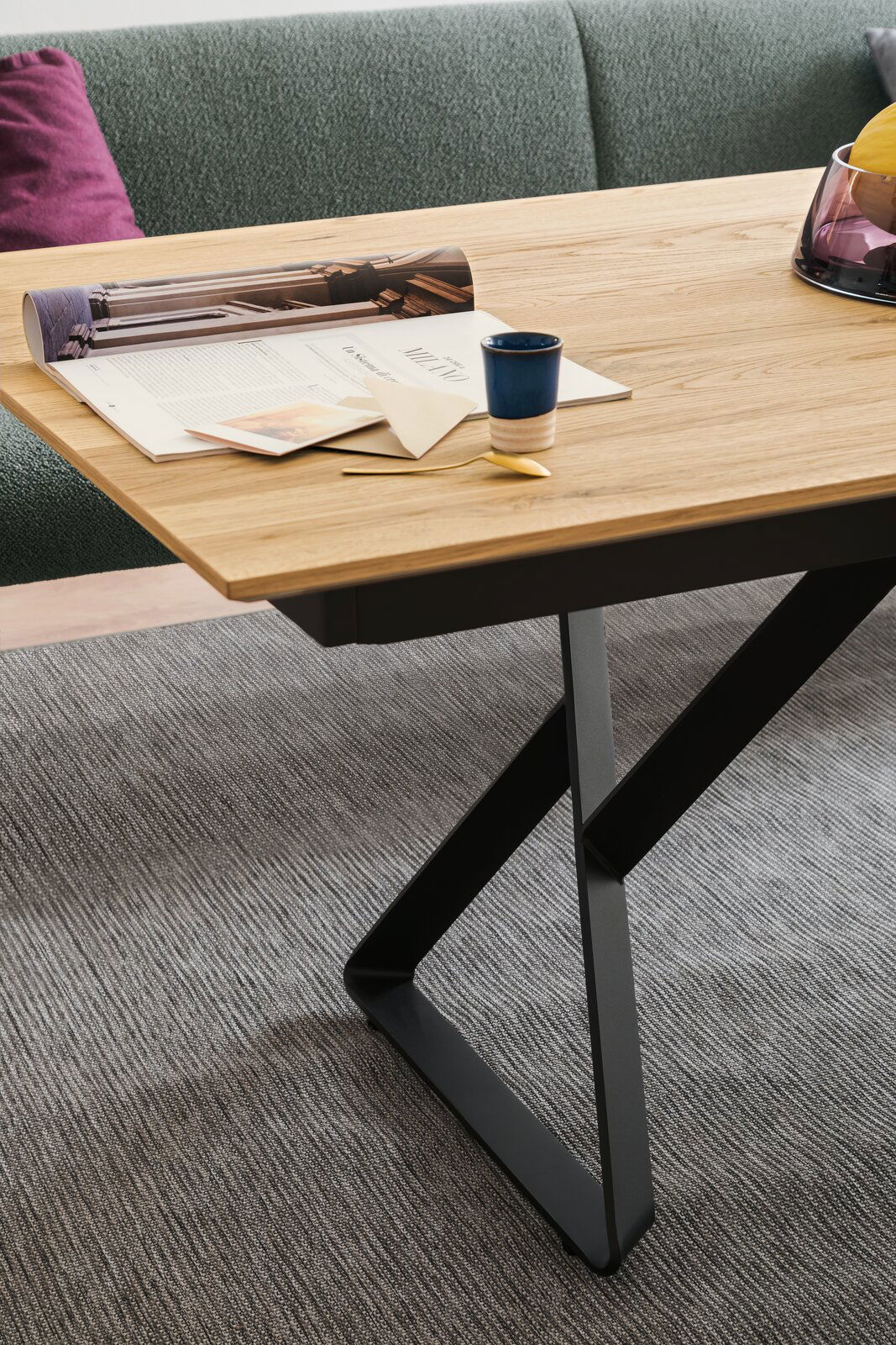 Moderner Esstisch mit Holzplatte und schwarzem Metallgestell, seitliche Perspektive