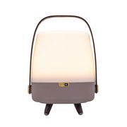 Frontansicht einer tragbaren Lampe mit integriertem Lautsprecher, cremefarbenes Licht und braunem Gehäuse, mit einem Griff oben.