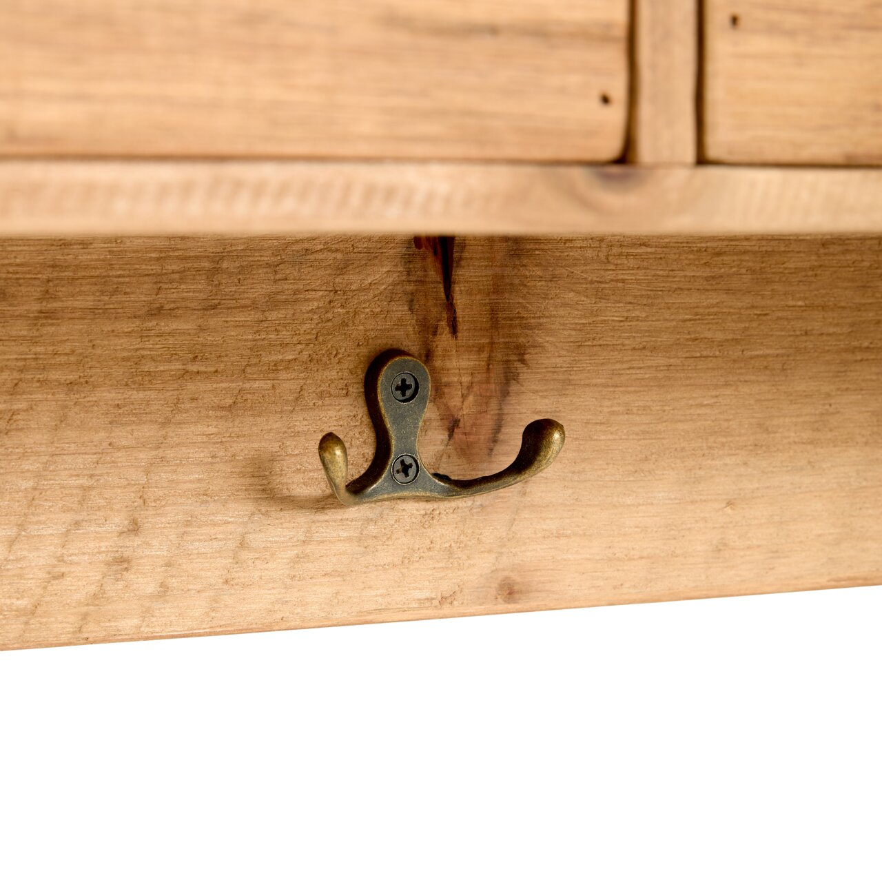 Close-up van een houten plank met een antieke dubbele metalen haak, gezien van onderaf.