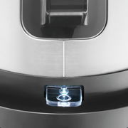 Nahaufnahme eines Wasserkochers mit Edelstahloberfläche und beleuchtetem Schalter, von oben betrachtet.