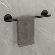 Schwarze Badetuchstange Uno 40 cm mit grauem Handtuch, montiert an einer grauen Steinwand, seitliche Perspektive