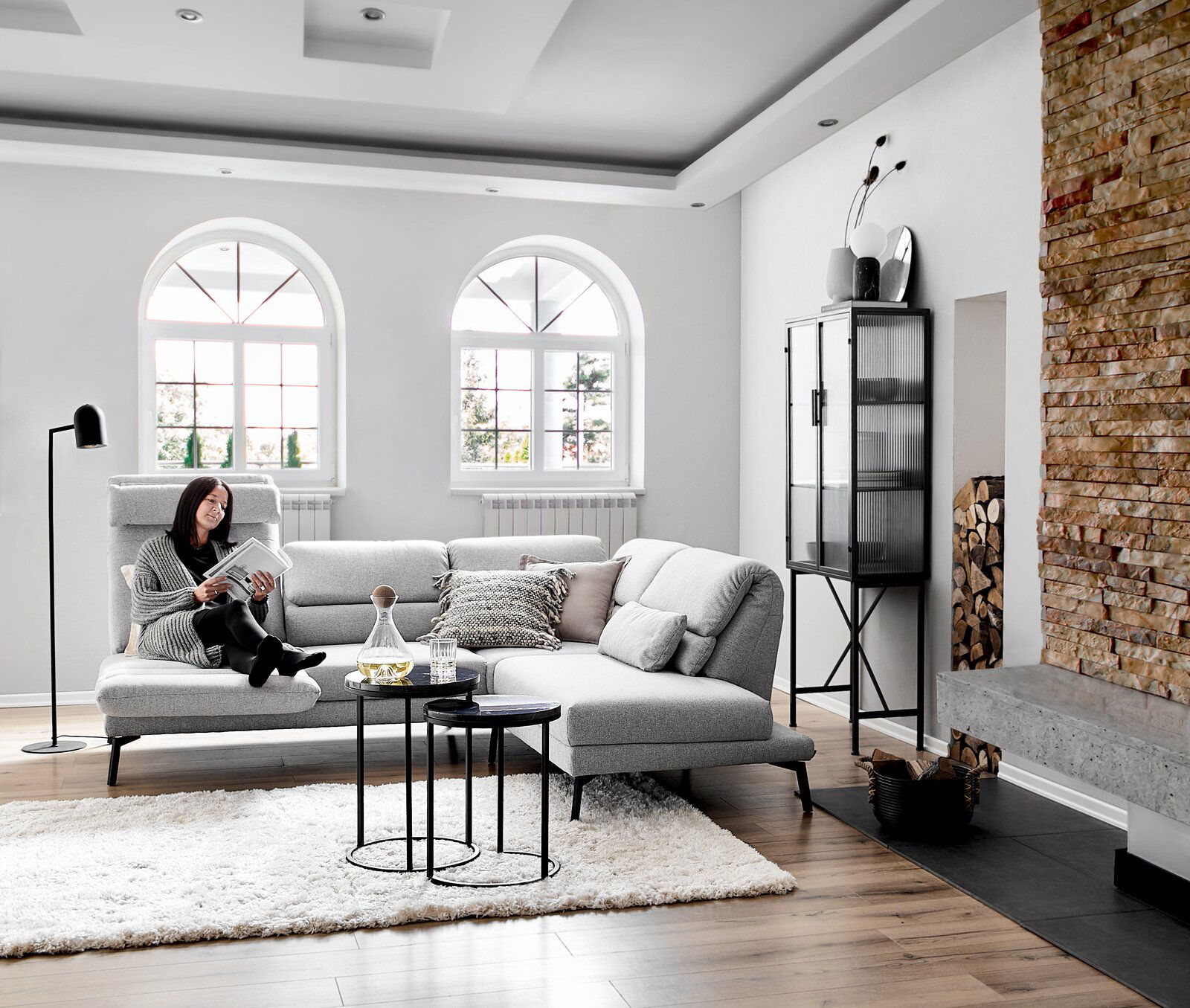 Dieter Knoll Ecksofa COSIO Gemütliches Ecksofa Dieter Knoll COSIO in einem modernen Wohnzimmer, seitliche Perspektive, mit einer Person, die ein Buch liest.