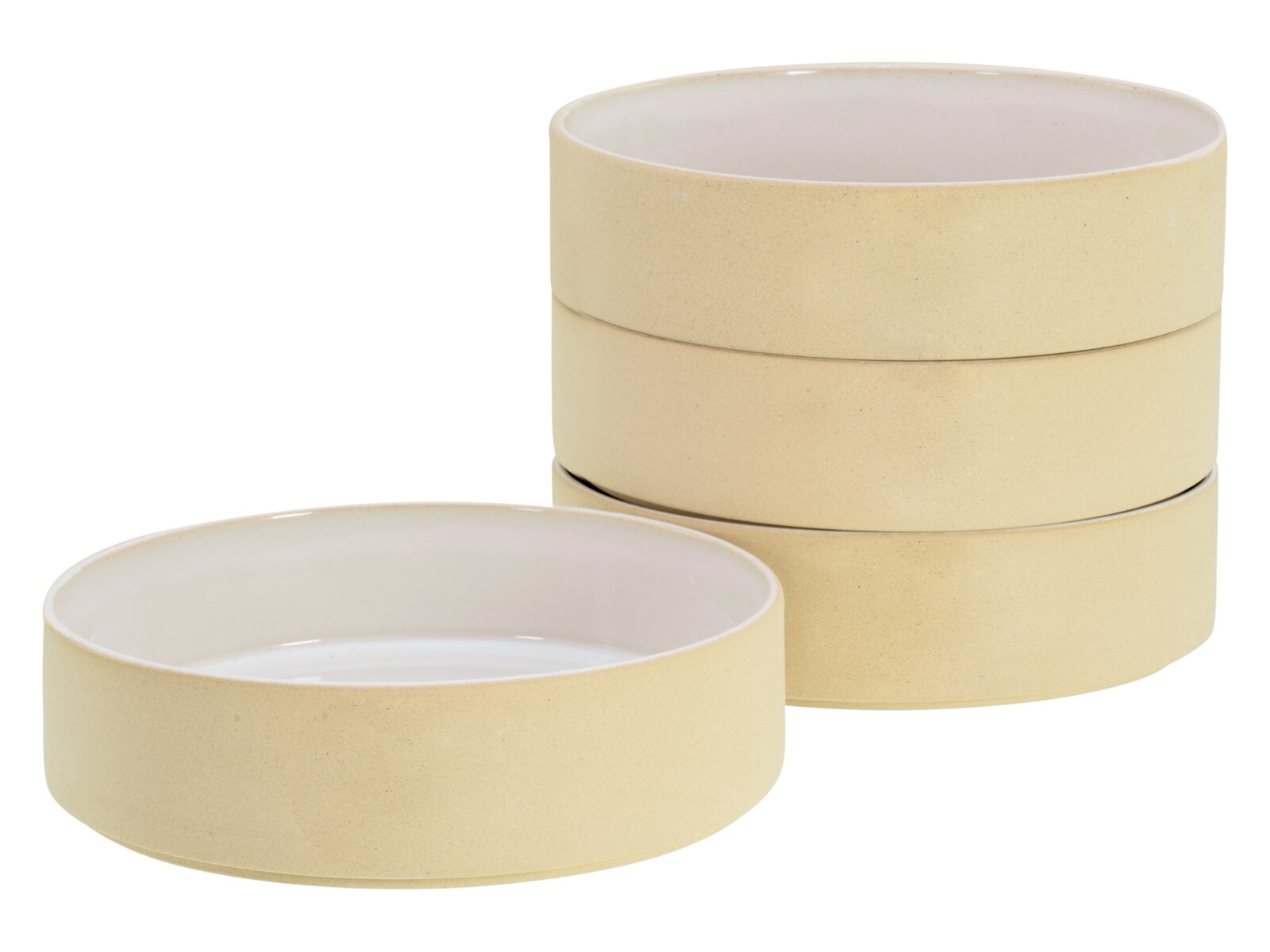 Vier stapelbare Keramikschalen in Creme/Beige mit weißer Innenglasur, eine Schale vorne liegend und drei dahinter gestapelt, freigestellt auf weißem Hintergrund, Perspektive: leicht von oben in 3/4-Ansicht