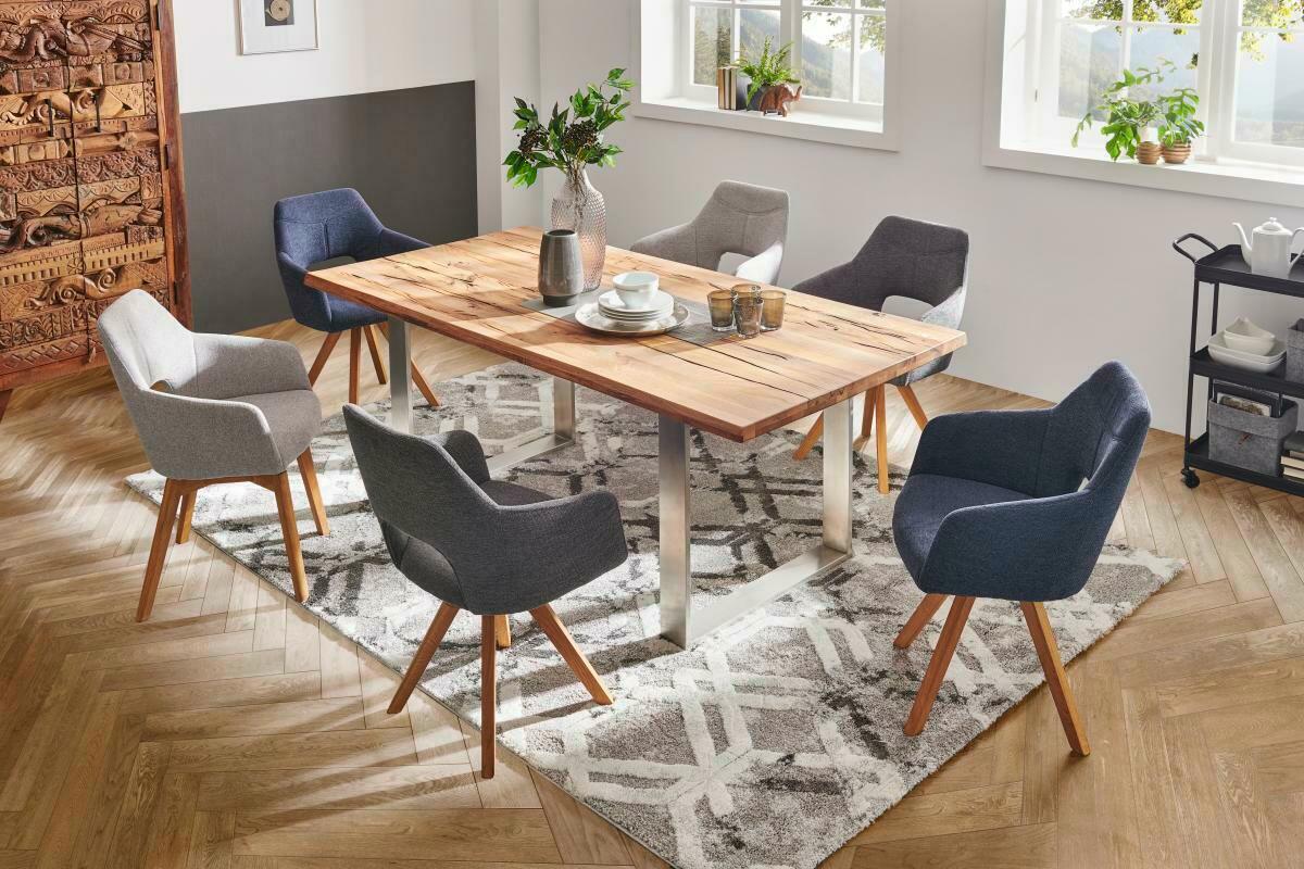 Esszimmer mit modernem Holztisch und sechs gepolsterten Sesseln in verschiedenen Grautönen, Perspektive von schräg oben.