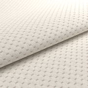 Nahaufnahme eines beigen, strukturierten Stoffes mit geometrischem Muster, perspektivisch von der Seite aufgenommen.