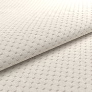 Nahaufnahme eines beigen, strukturierten Stoffes mit geometrischem Muster, perspektivisch von der Seite aufgenommen.