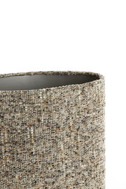 Nahaufnahme eines zylindrischen Lampenschirms mit texturierter, gewebter Oberfläche in neutralen Farbtönen, seitliche Perspektive.