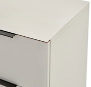 Detailaufnahme eines weißen Schranks mit Glasplatte oben und dunklem Griff, perspektivisch von schräg oben vorne