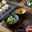 Nahaufnahme eines 29-teiligen Sushi-Tellersets in Anthrazit, präsentiert mit Sushi, Suppe und Gemüse-Dip auf einem Holztisch.