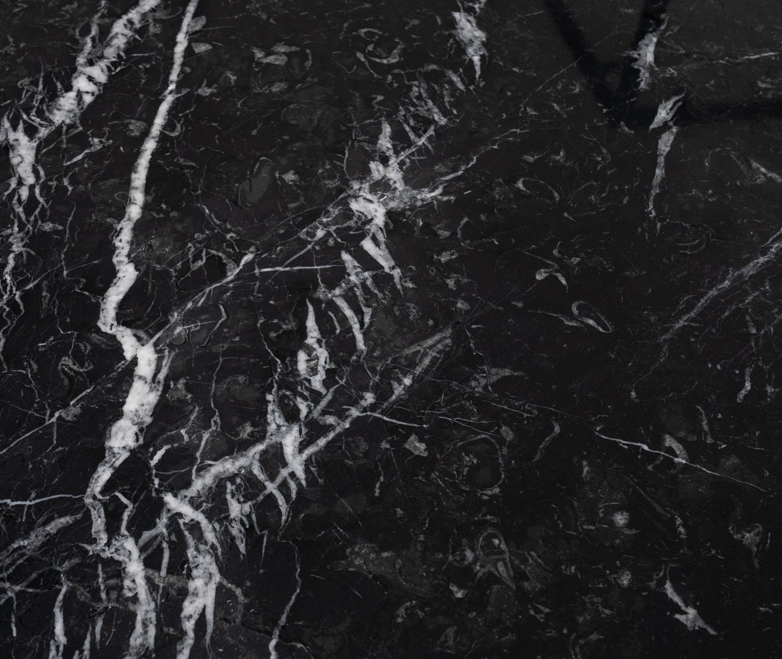 Nahaufnahme einer schwarzen Marmoroberfläche mit weißen Adern, Draufsicht
