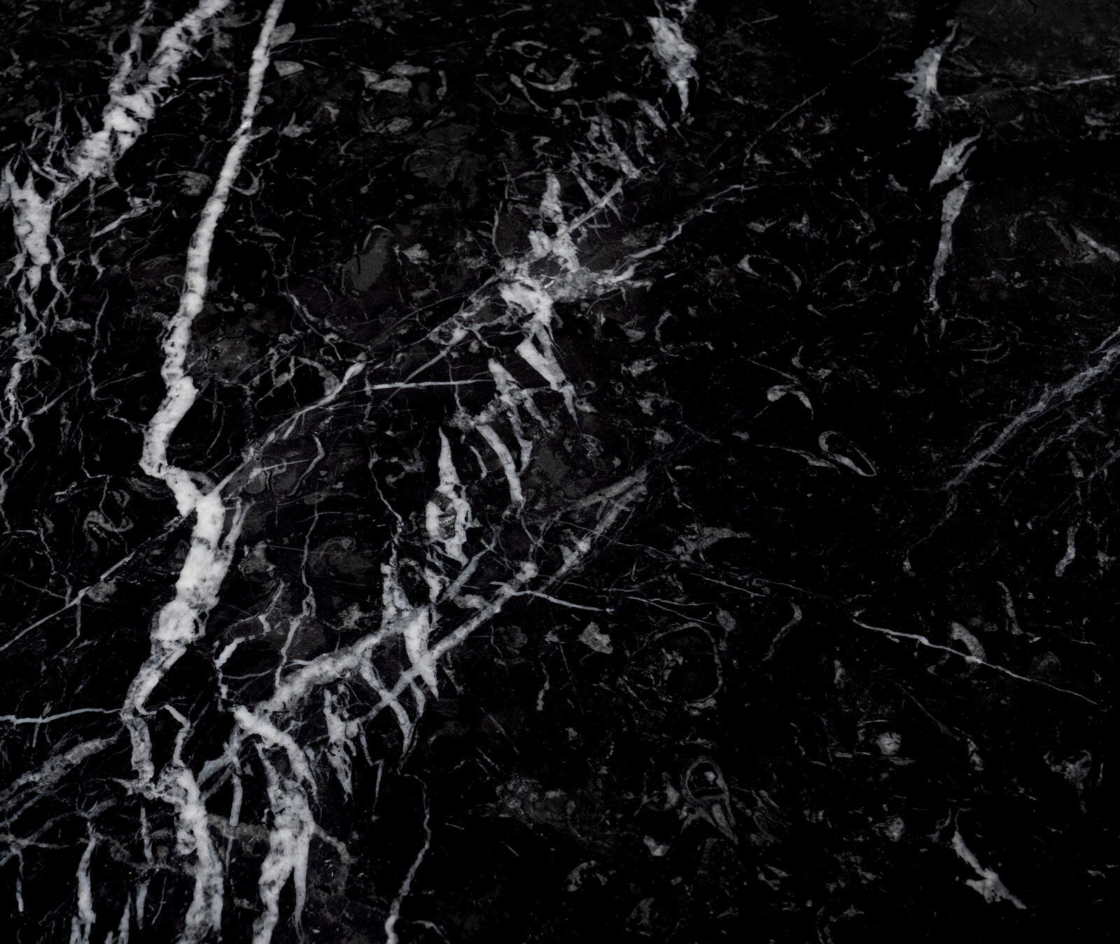 Nahaufnahme einer schwarzen Marmoroberfläche mit weißen Adern, Draufsicht