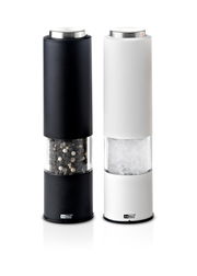 Zwei moderne Mühlen, eine schwarz und eine weiß, gefüllt mit Pfefferkörnern und grobem Salz, aus der Frontalperspektive.