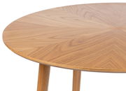 Nahaufnahme eines runden Esstisches aus Holz mit sichtbarer Maserung, von oben betrachtet.