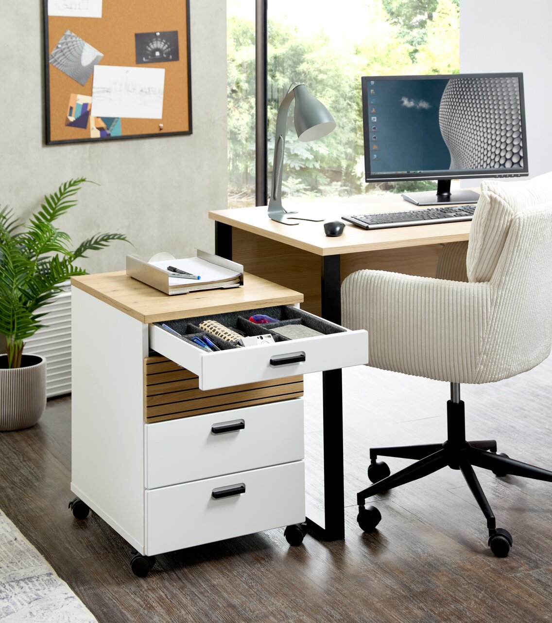 Rollcontainer mit drei Schubladen, auf Rollen, in einem modernen Büro, seitliche Perspektive.