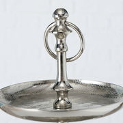 Nahaufnahme einer silbernen Etagere aus der Serie PASSIA von AluBoltze, mit einem eleganten, glänzenden Finish und einem dekorativen Griff. Perspektive von oben auf die obere Ebene.