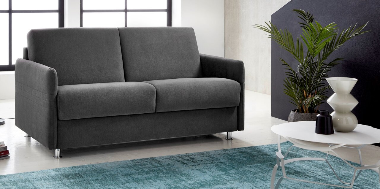 Graues Schlafsofa in modernem Wohnzimmer, seitliche Perspektive.