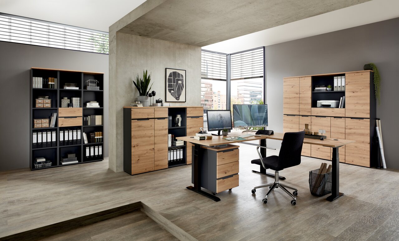 Moderne Büroumgebung mit Voleo E-Eckschreibtisch DETROIT, Aktenschränken und Regalen in Holzoptik, seitliche Perspektive.